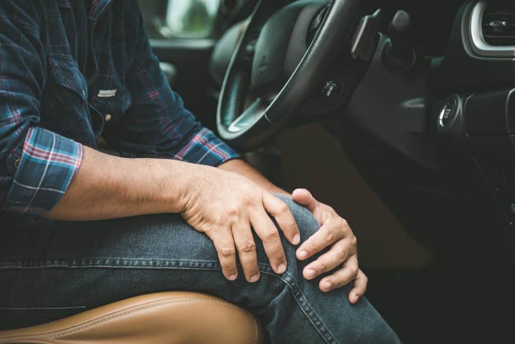 Man Having Knee Pain In The Car | Personal Injury Law Firm in NYC | Gash & Associates, P.C.