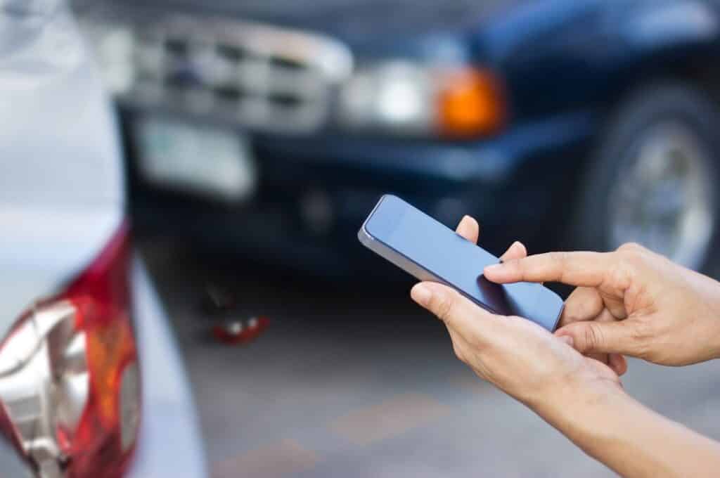 Woman Using Smartphone After Car Accident | Motor Vehicle Accident Lawyers | Gash & Associates, P.C.
