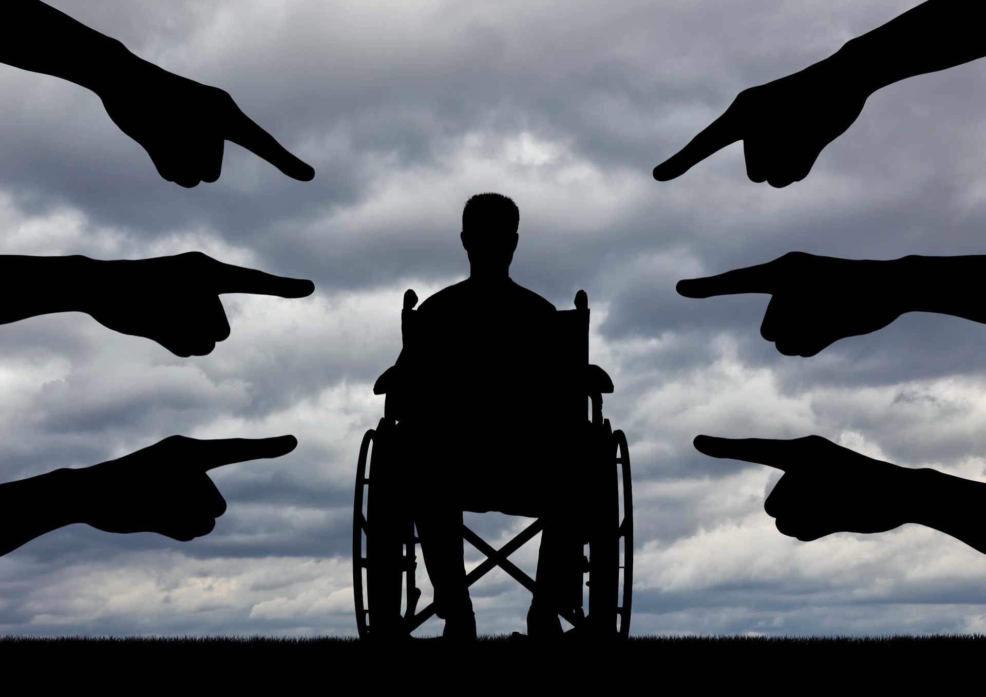 A disabled person in a wheelchair, people hands showing a finger at him.
