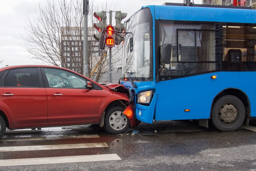 A blue bus in a frontal collision with a red car
