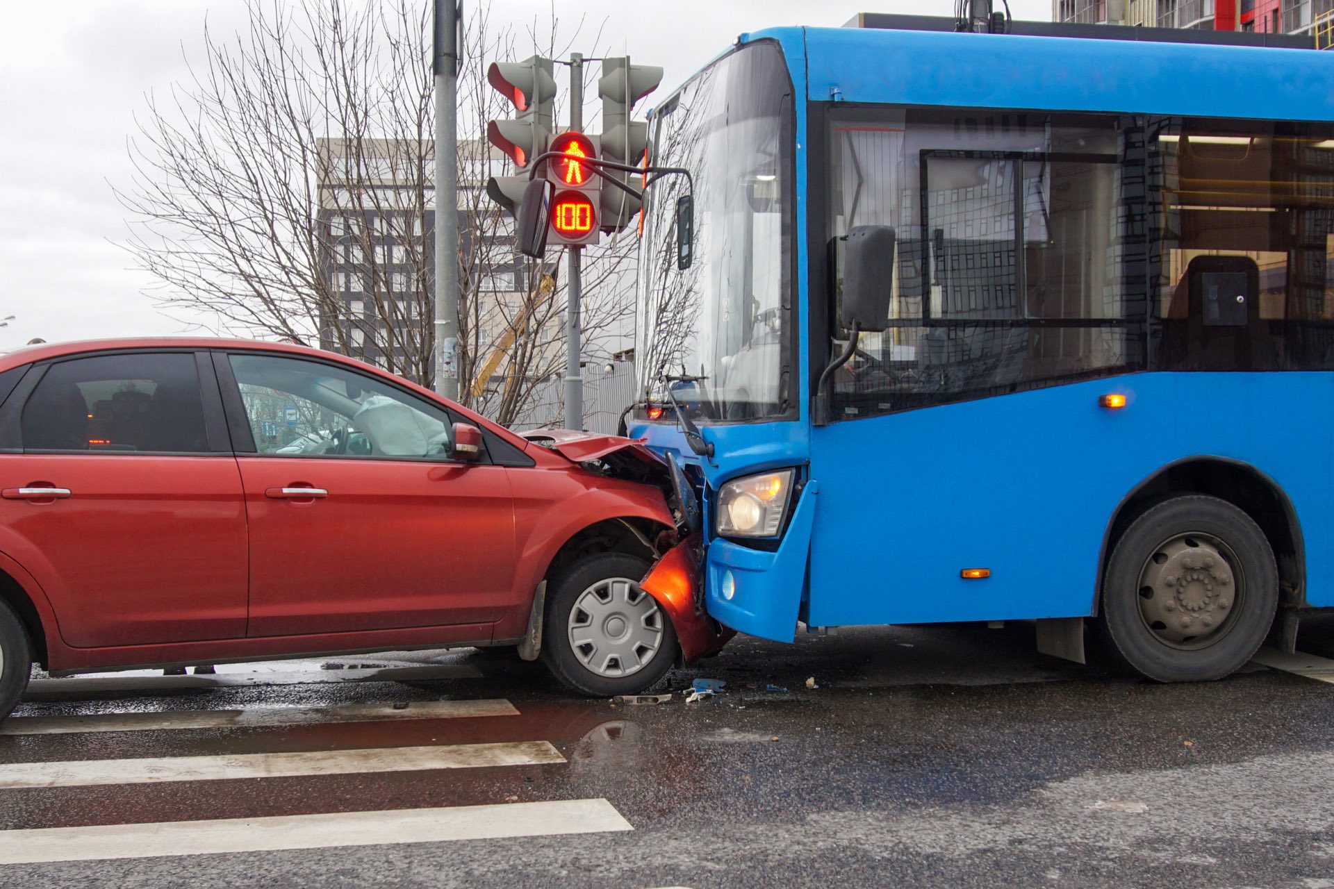 A blue bus in a frontal collision with a red car