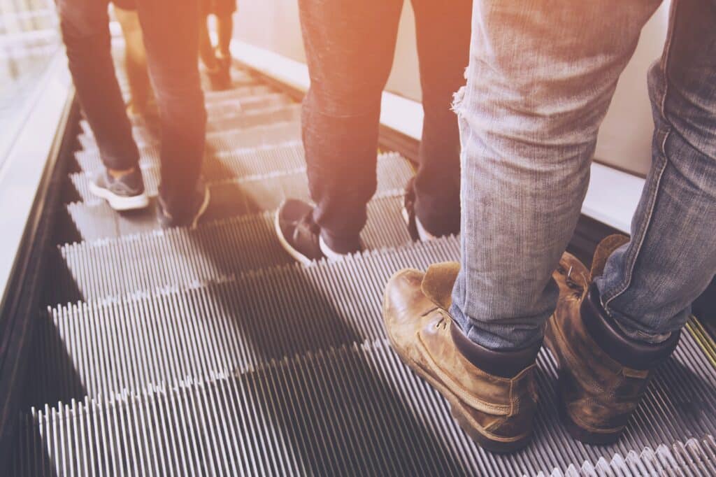 Legs Shoes Of People Using Escalator | Premises Liability Attorney in NYC | Gash & Associates, P.C.