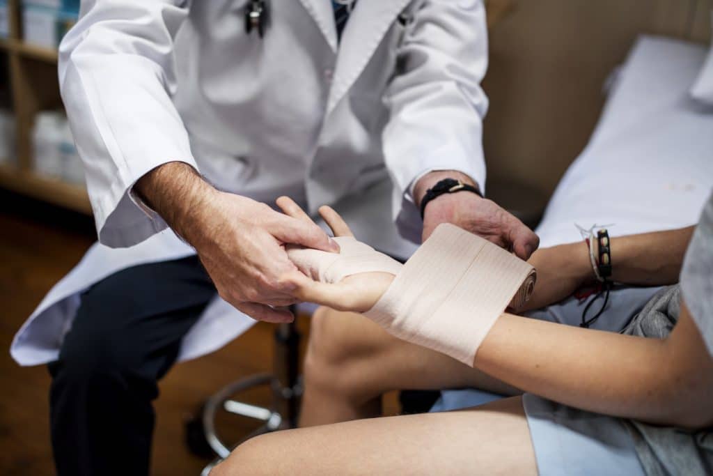 Doctor Puts Plaster On Patient's Injured Arm | Workplace Injury Lawyers | Gash & Associates, P.C.