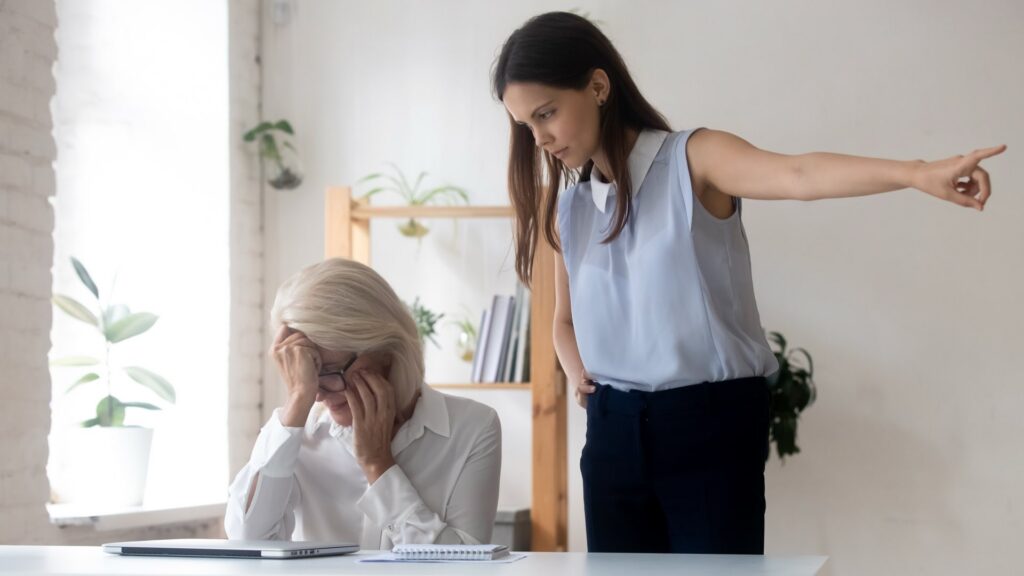 Angry young female asking middle-aged employee leave office.