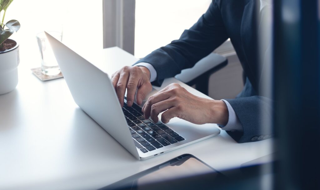 Person sitting at desk typing on a laptop