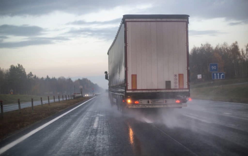 Tractor-trailer merging into passing lane during rain storm