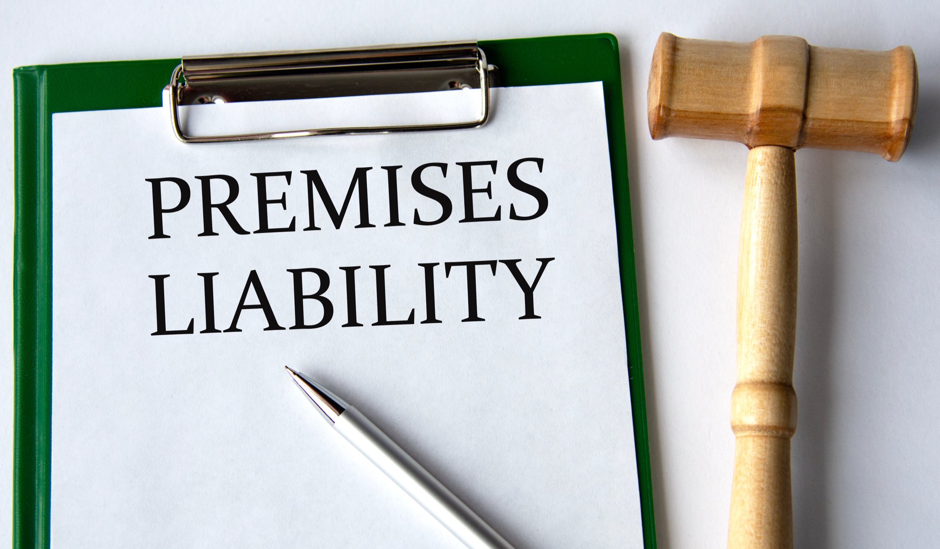 Wooden gavel next to a clipboard that says premises liability