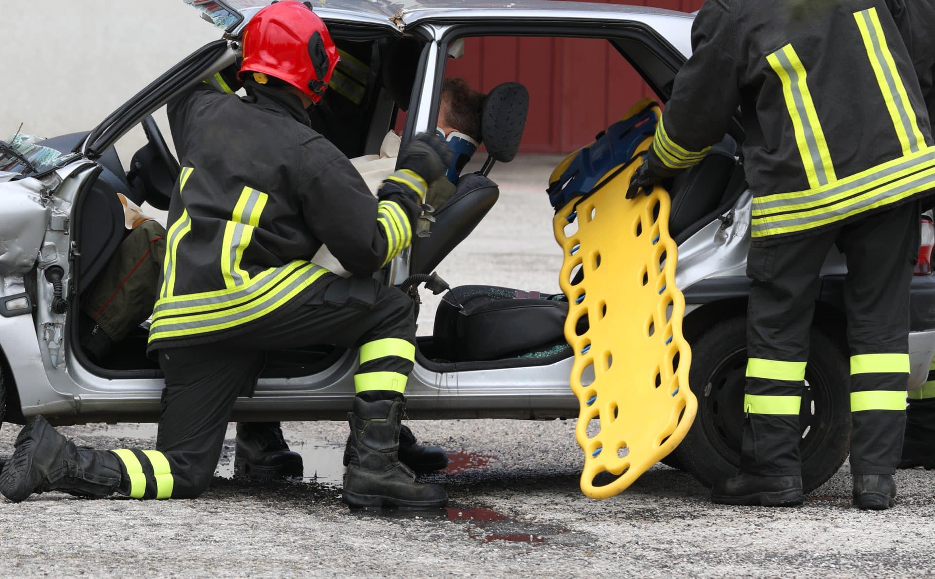 Team if firefighters tending to car crash victim