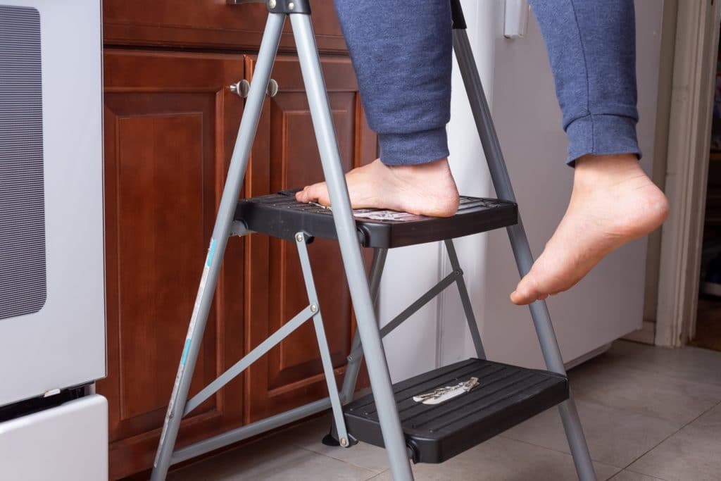 Man's Feet On A Two Level Step Ladder | Product Liability Attorneys in NYC | Gash & Associates, P.C.