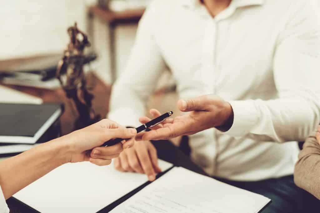 Lawyer Giving The Client A Pen To SIgn | Personal Injury Law Firm in NYC | Gash & Associates, P.C.