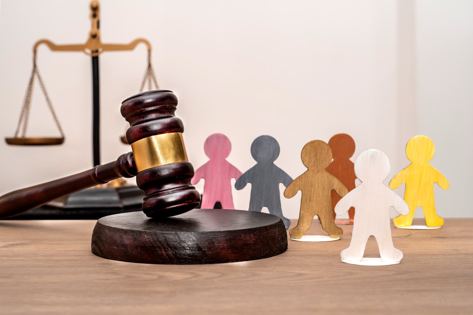 A judge's gavel next to various human figures