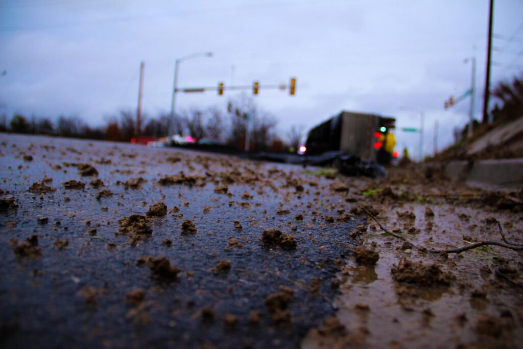 An overturned truck in an intersection with scattered debris on the road.