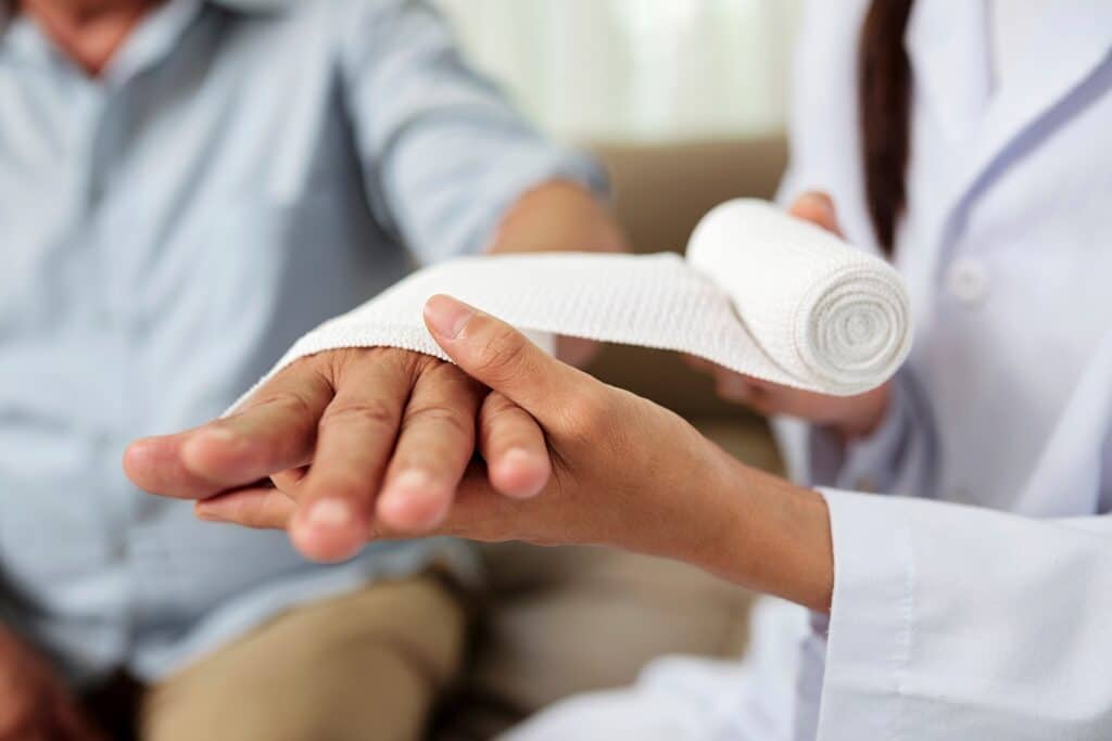 Doctor Putting Bandage on Injured Hand | Nursing Home Negligence Lawyers | Gash & Associates, P.C.