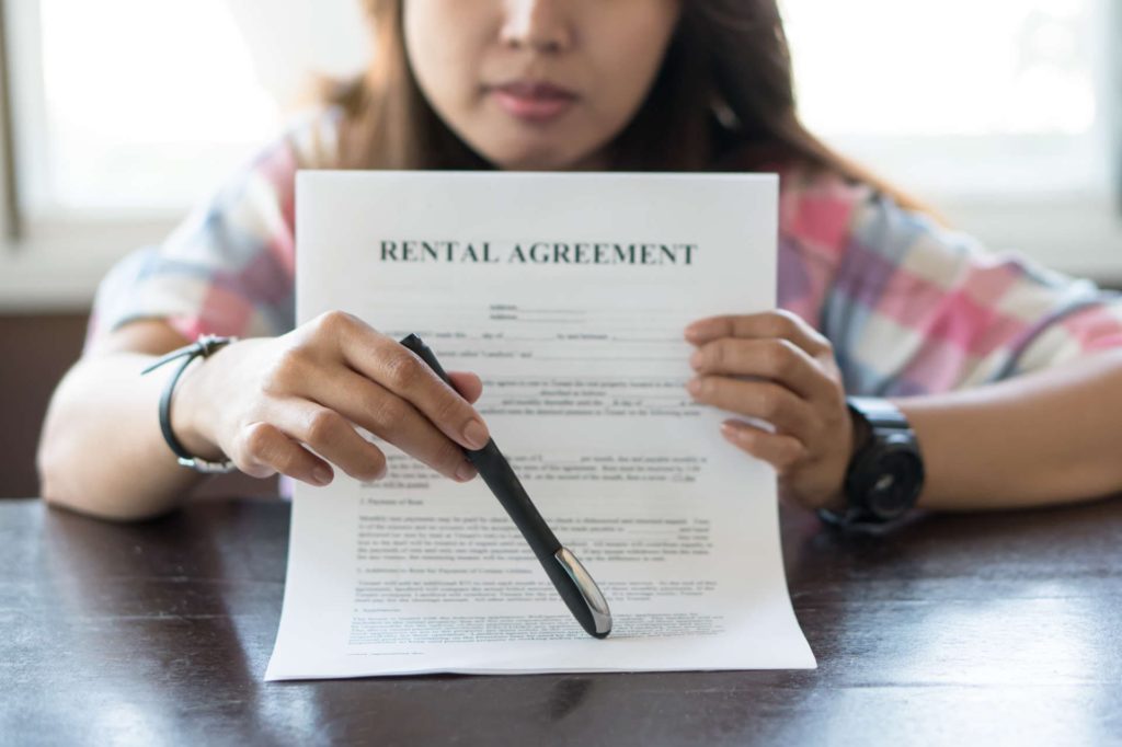 Woman Holding Rental Agreement Document | Landlord Premises Liability | Gash & Associates, P.C.