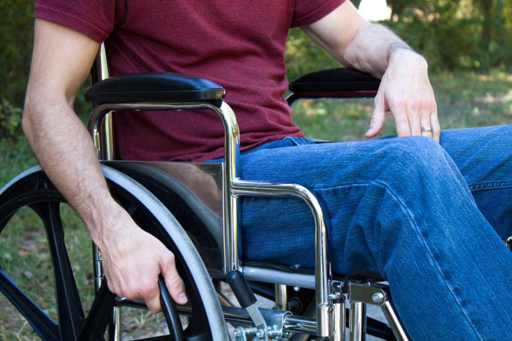 Man in red t-shirt and bluejeans in wheelchair