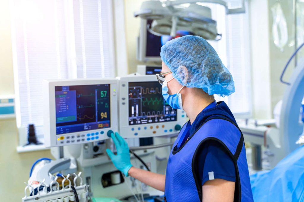 nurse checks patient's vitals on medical device