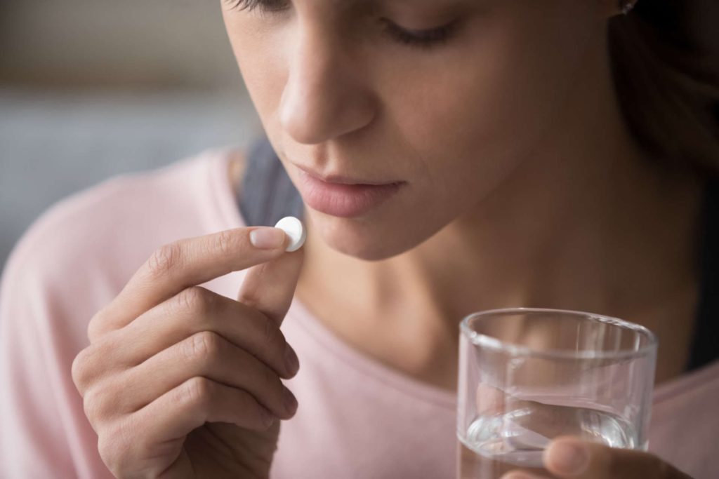 Woman Holding Pill and Glass of Water | Wrongful Death Attorneys in NYC | Gash & Associates, P.C.